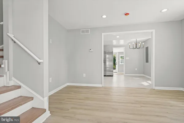 a view of interior space with wooden floor and kitchen view