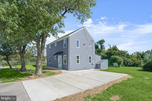 a front view of a house with a yard and trees