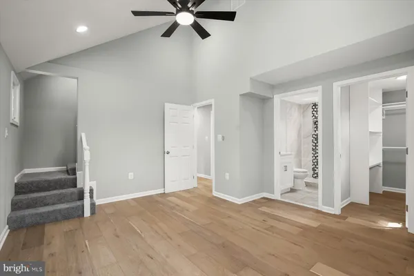 an empty room with wooden floor cabinet and windows