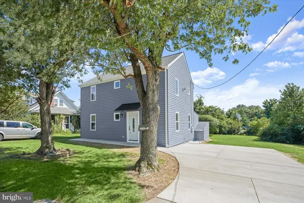a front view of a house with a yard and a tree