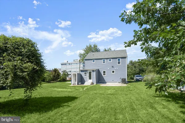 a view of a house with a big yard and a large tree