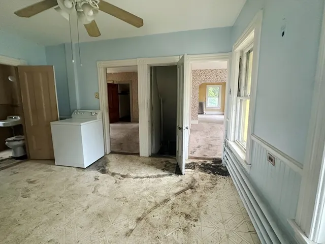 en empty room with an entryway and chandelier fan