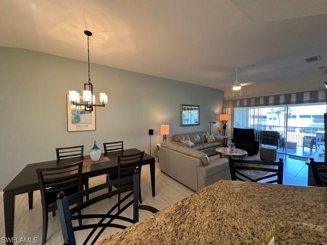 6800 Satinleaf Road South, Unit 202 Naples, FL 34109 - Photo 5 of 15 a living room with furniture a window and a chandelier