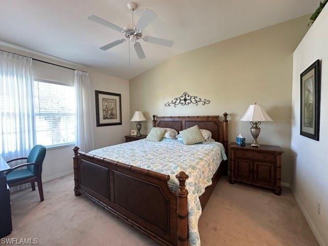 6800 Satinleaf Road South, Unit 202 Naples, FL 34109 - Photo 10 of 15 a bedroom with a bed and a chandelier