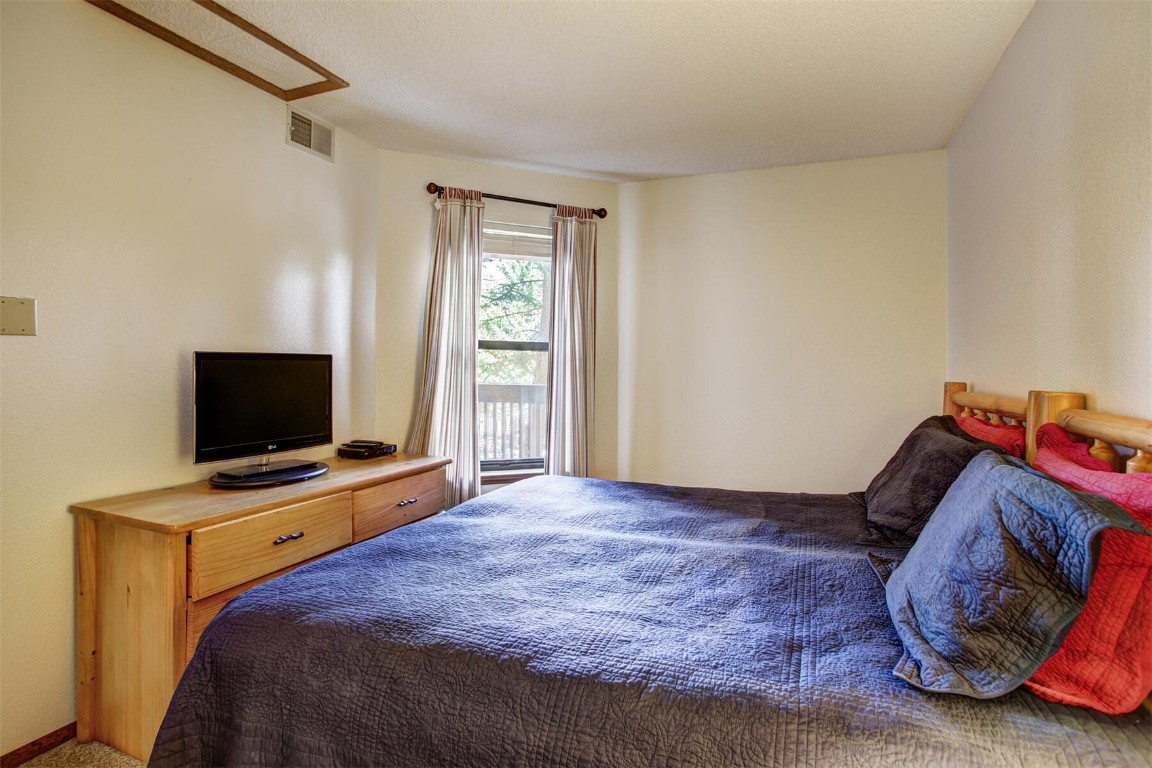 570 Bills Ranch Road, Unit 115 Frisco, CO 80443 - Photo 16 of 31 a bedroom with a bed and a flat screen tv