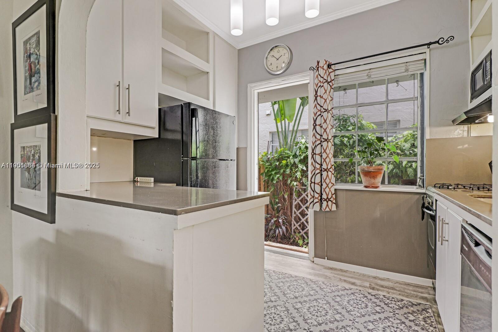 1250 Drexel Avenue, Unit 7 Miami Beach, FL 33139 - Photo 14 of 30 a kitchen with stainless steel appliances a refrigerator sink and cabinets