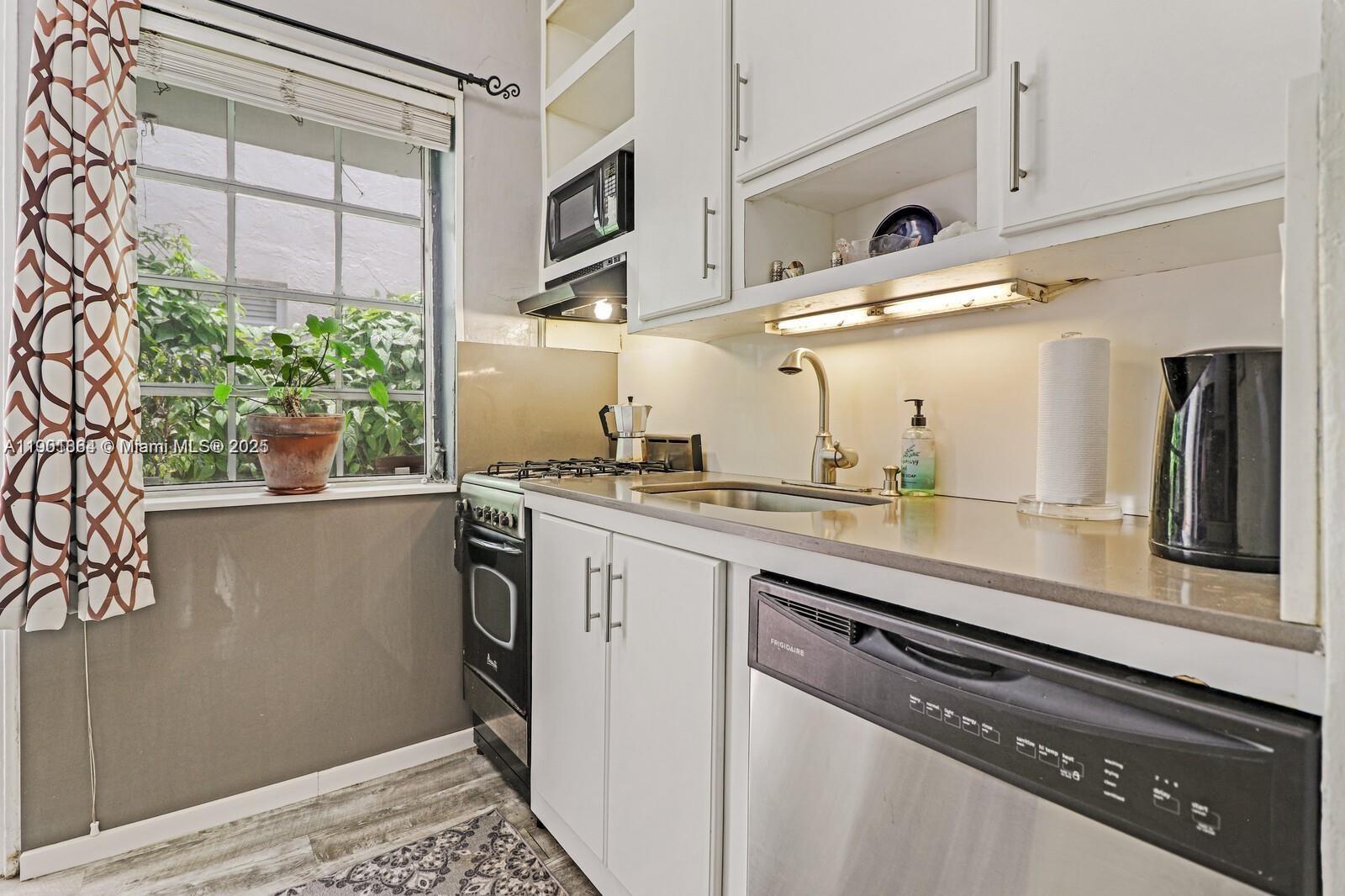 1250 Drexel Avenue, Unit 7 Miami Beach, FL 33139 - Photo 15 of 30 a kitchen with stainless steel appliances granite countertop a sink a stove and a window
