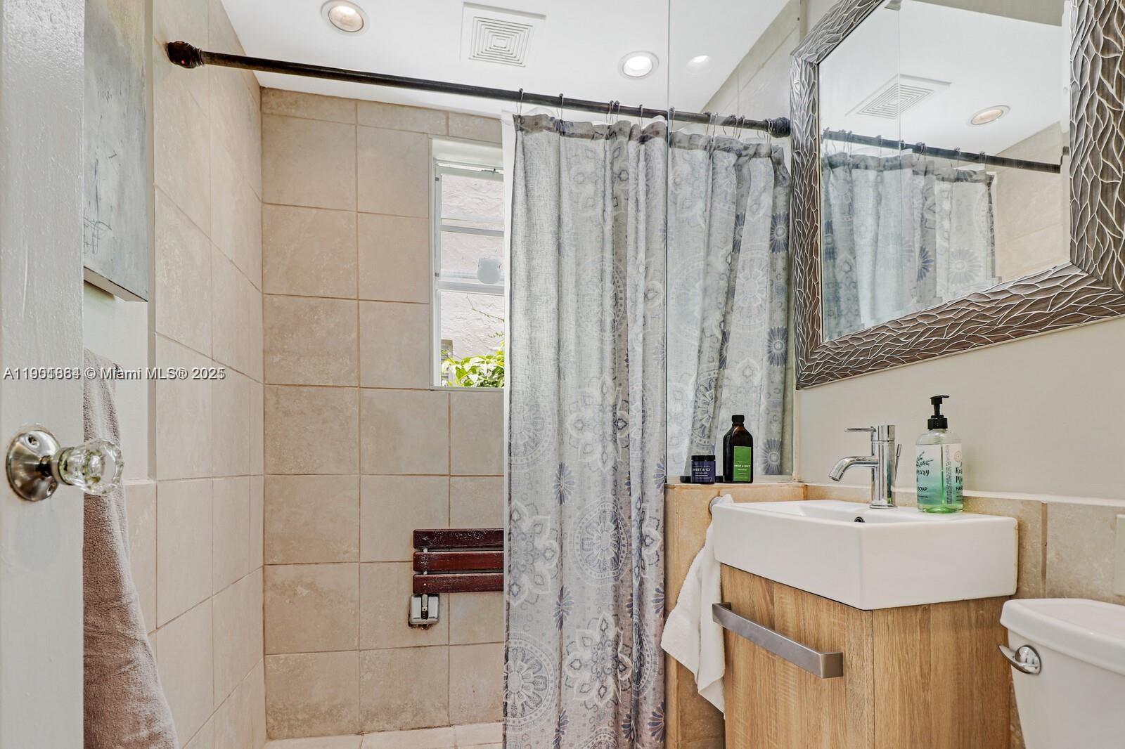 1250 Drexel Avenue, Unit 7 Miami Beach, FL 33139 - Photo 22 of 30 a bathroom with a sink vanity granite toilet and shower