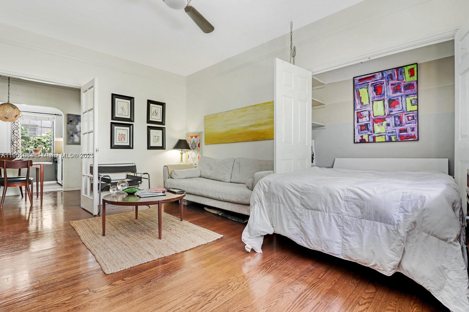 1250 Drexel Avenue, Unit 7 Miami Beach, FL 33139 - Photo 4 of 30 a spacious bedroom with a bed a couch and paintings on the wall