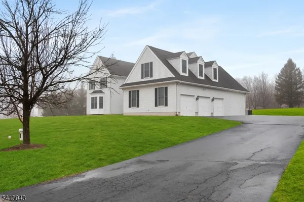 a view of a big house with a big yard and large trees
