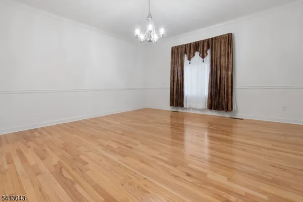 a view of a room with wooden floor and chandelier
