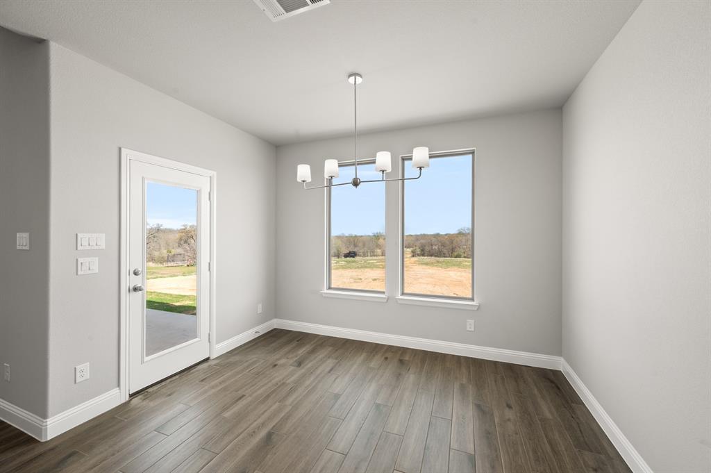 7016 Ranch View Place Springtown, TX 76082 - Photo 12 of 29 an empty room with wooden floor and windows