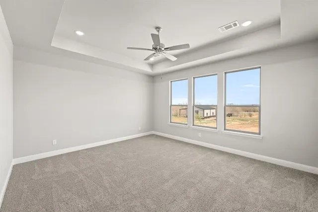 an empty room with a window and a ceiling fan