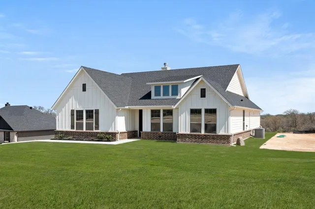a front view of a house with a yard and trees
