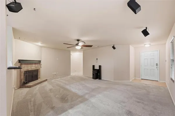 a view of an empty room with a fireplace and a window
