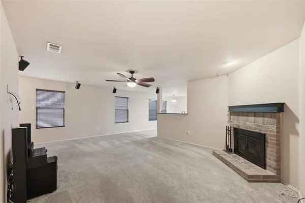 an empty room with windows and fireplace