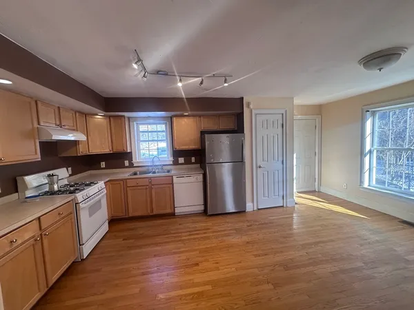 a kitchen with granite countertop a refrigerator stove top oven and sink