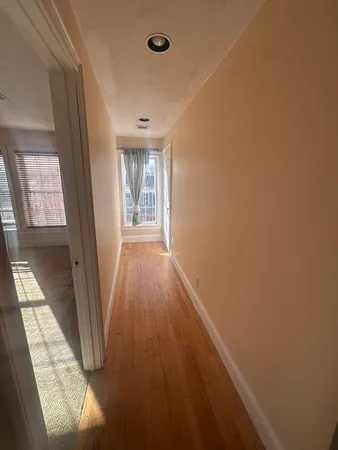 a view of hallway with wooden floor and chandelier