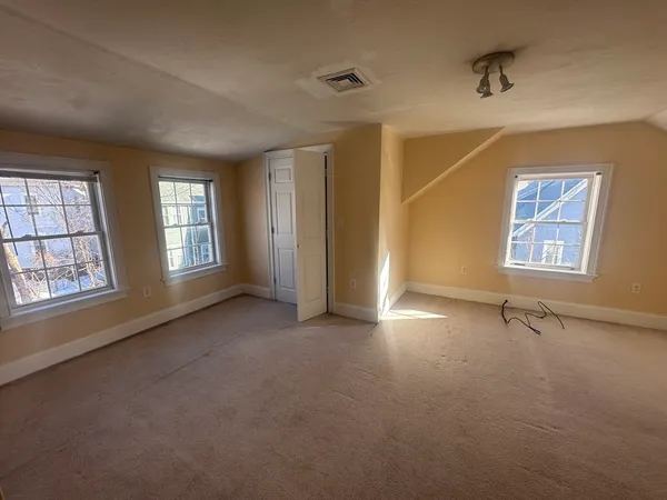 an empty room with windows and closet