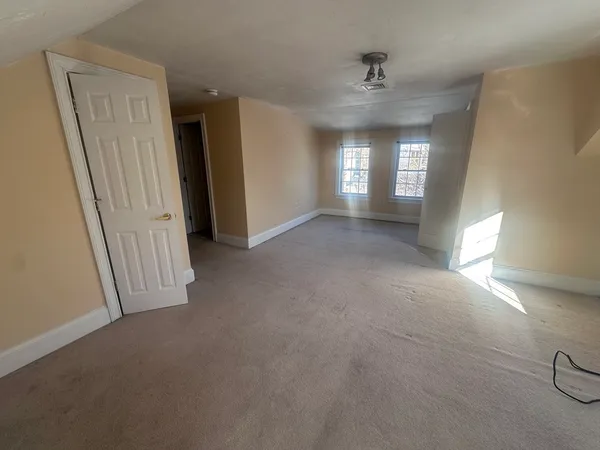 an empty room with windows and cabinet