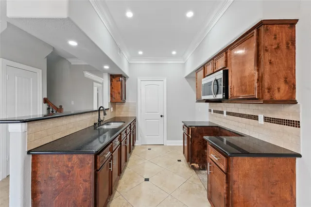 a kitchen with stainless steel appliances granite countertop a sink stove and microwave