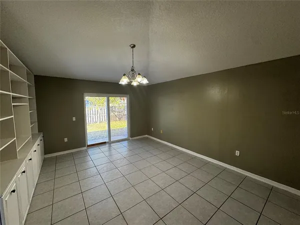 an empty room with windows and chandelier