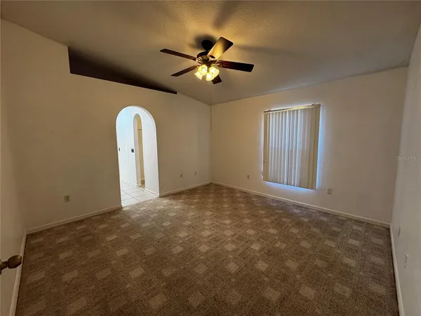 a view of a livingroom with a ceiling fan and window