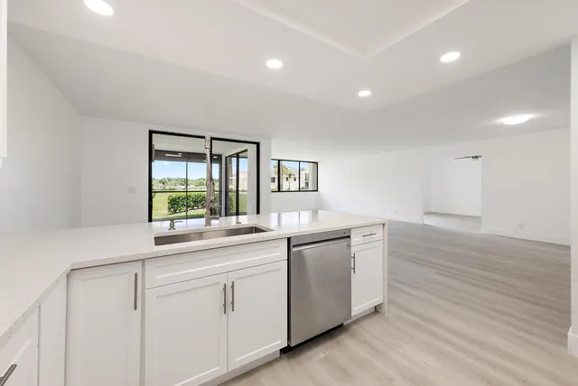 a kitchen with granite countertop white cabinets and white appliances