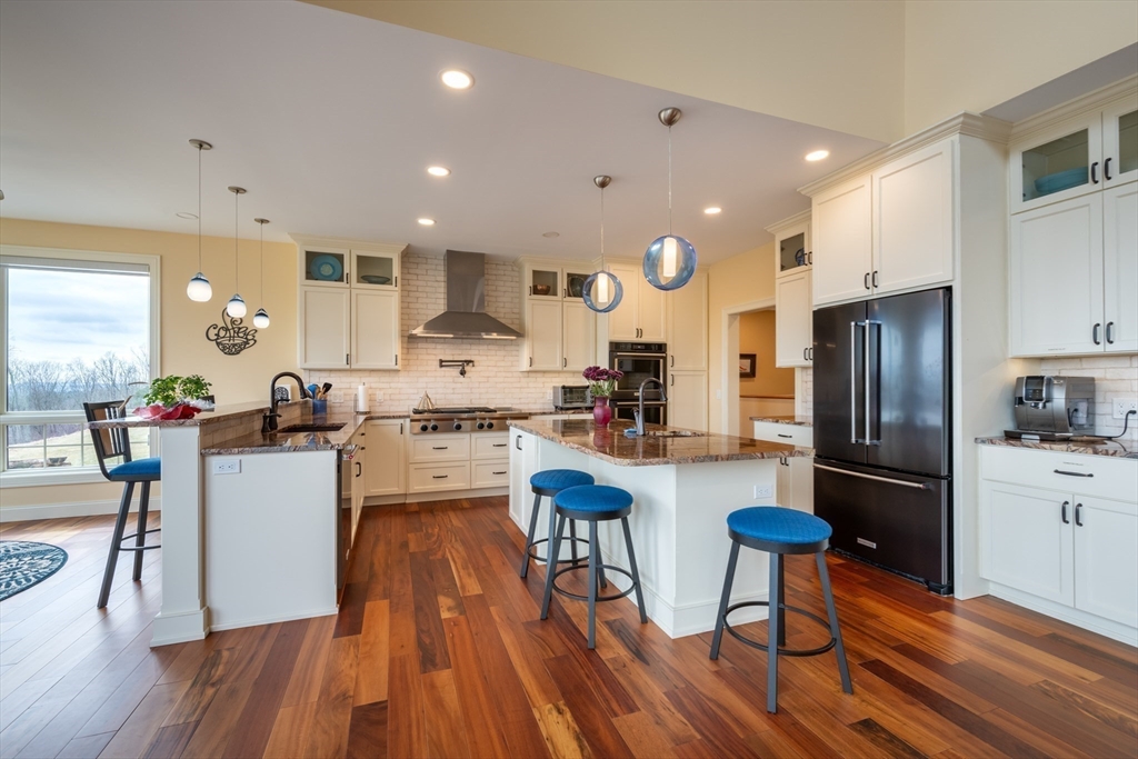 1089 Westhampton Road Northampton, MA 01062 - Photo 17 of 42 a kitchen with a refrigerator a stove and a wooden floor
