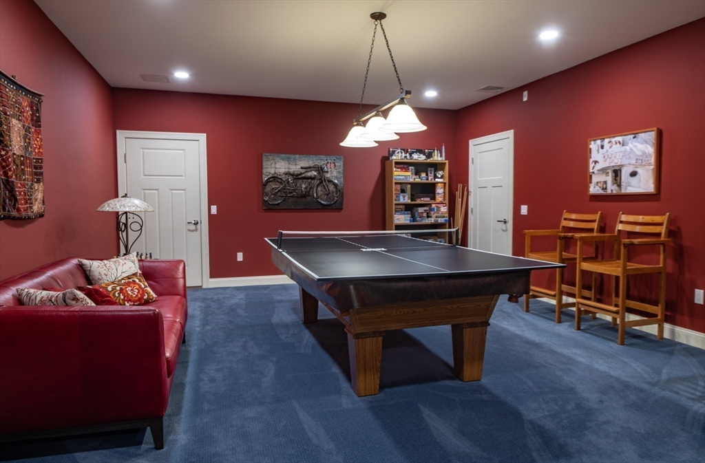 1089 Westhampton Road Northampton, MA 01062 - Photo 36 of 42 a living room with furniture a flat screen tv and a chandelier