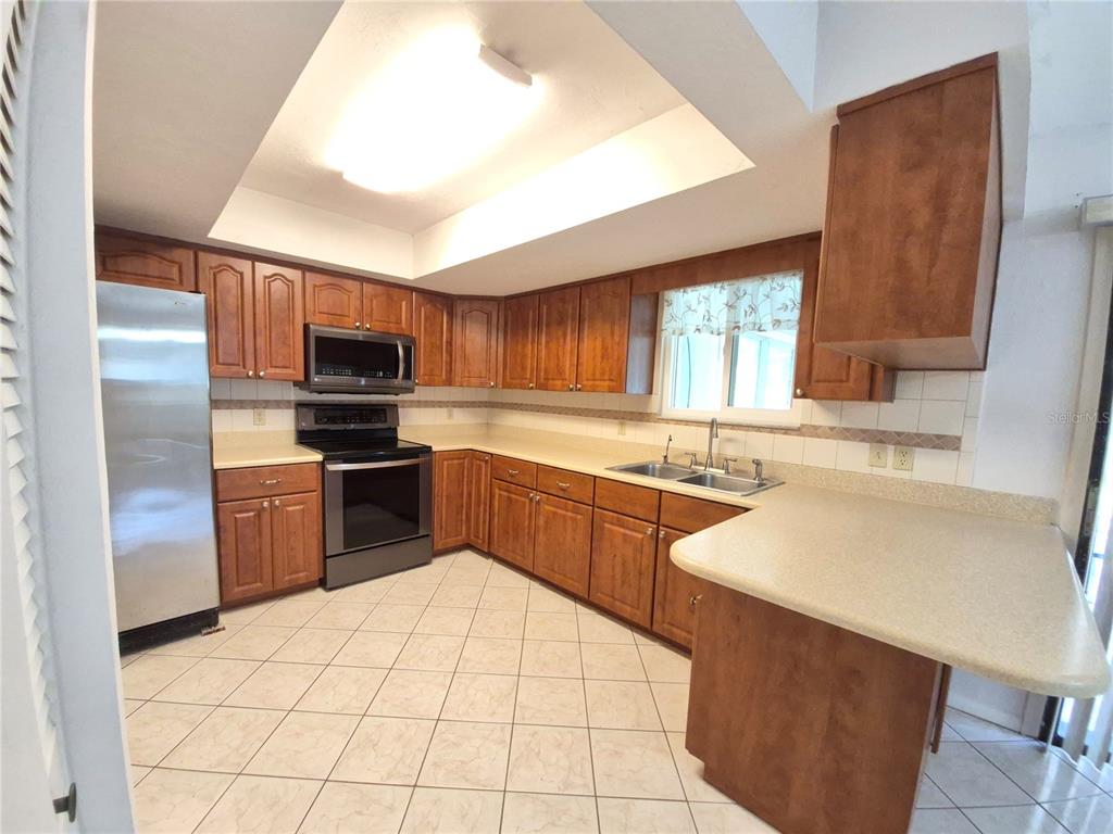 25632 Southwest 19 Avenue Newberry, FL 32669 - Photo 5 of 20 a kitchen with a sink a stove a refrigerator cabinets and a window