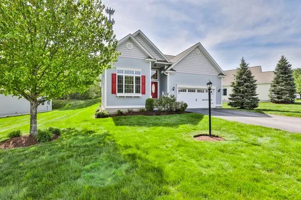 a front view of house with a garden and trees