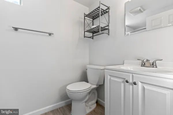 a bathroom with a toilet a sink and mirror
