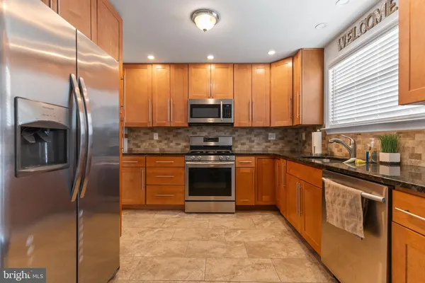 a kitchen with stainless steel appliances granite countertop a stove a sink and a refrigerator