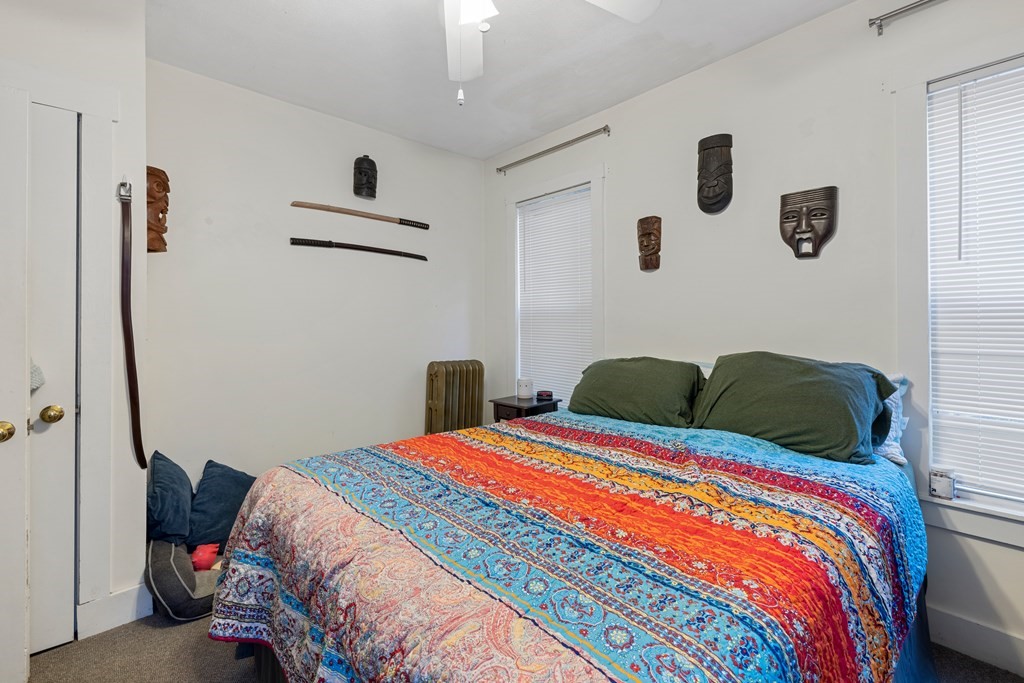 382 McGrath Highway Somerville, MA 02143 - Photo 14 of 31 a bedroom with a bed and a lamp with the wooden floor