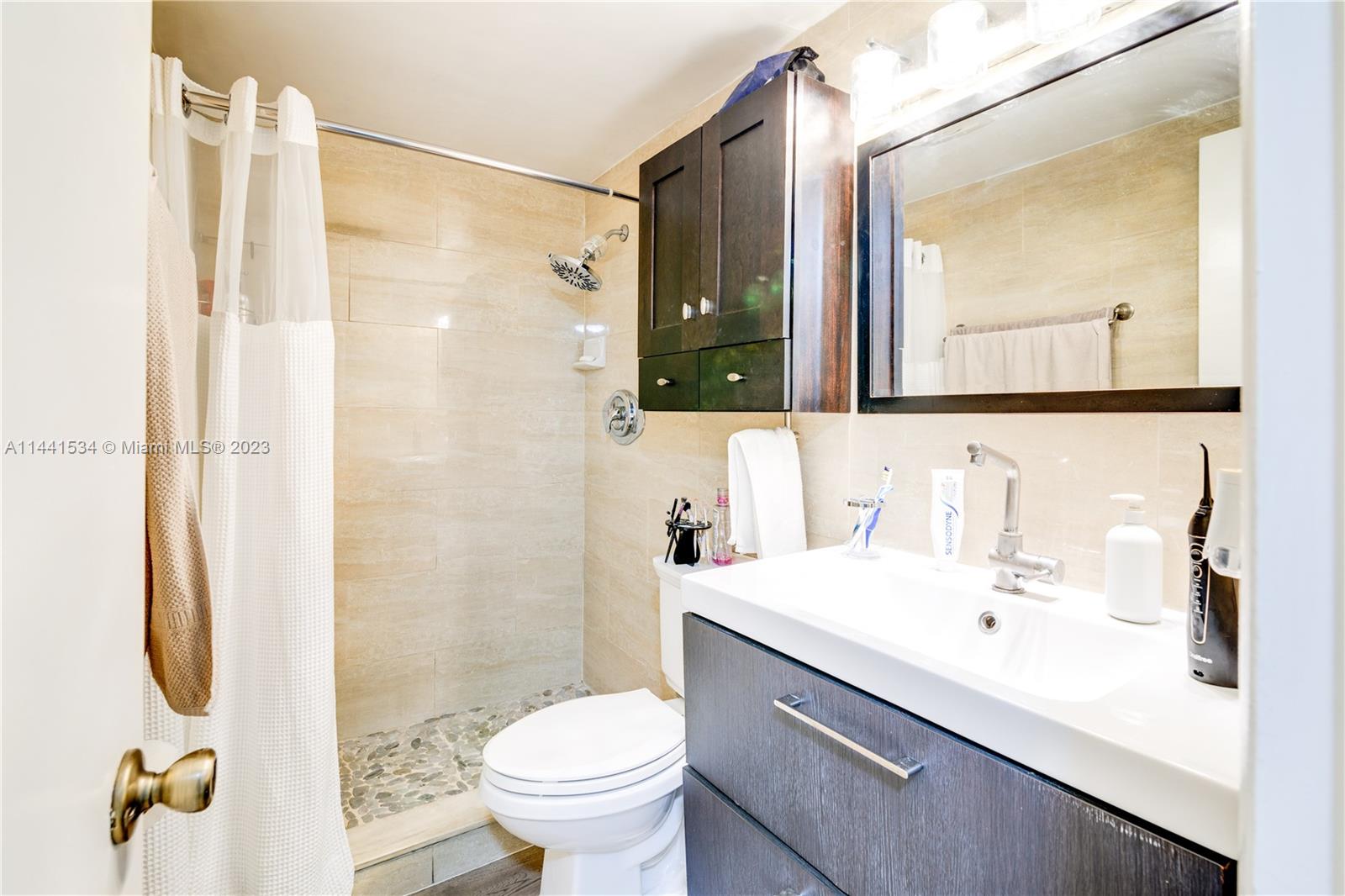 200 Northeast 12th Avenue, Unit 5B Hallandale Beach, FL 33009 - Photo 15 of 26 a bathroom with a sink toilet and shower