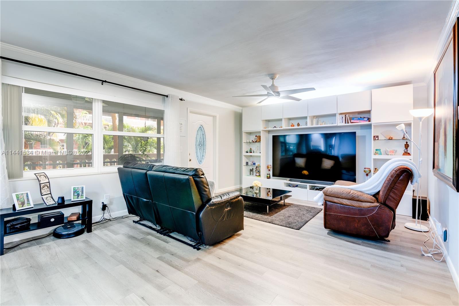 200 Northeast 12th Avenue, Unit 5B Hallandale Beach, FL 33009 - Photo 8 of 26 a living room with furniture flat screen tv and a large window