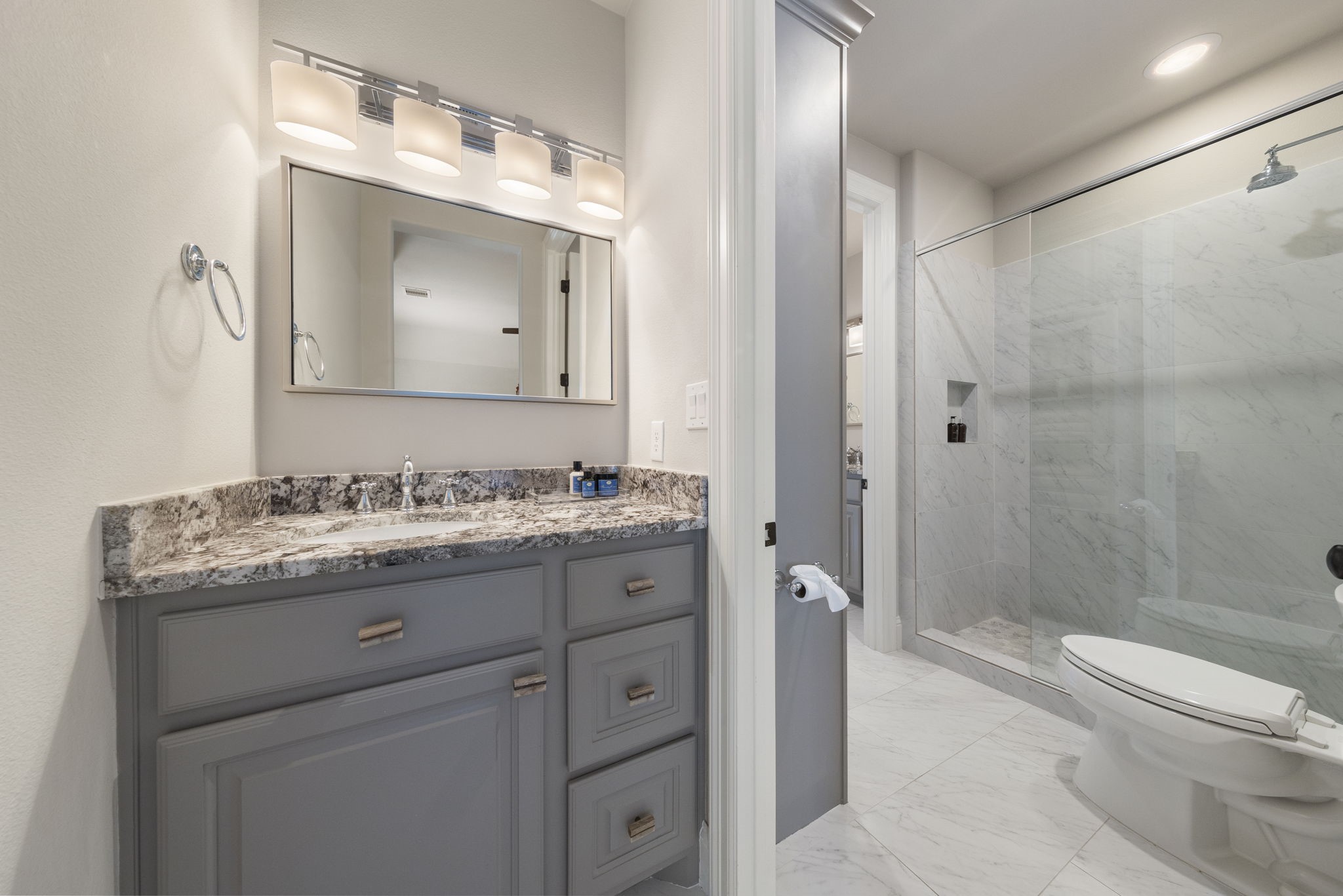 70 Lake Reverie Place Tomball, TX 77375 - Photo 26 of 33 a bathroom with a granite countertop toilet a sink and a mirror