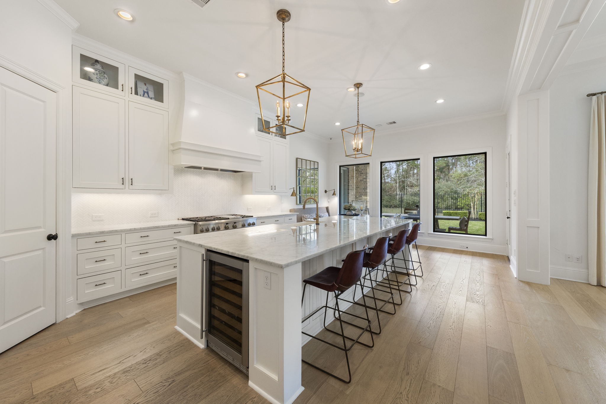 70 Lake Reverie Place Tomball, TX 77375 - Photo 9 of 33 a kitchen with stainless steel appliances kitchen island granite countertop a stove a refrigerator a sink dishwasher and white cabinets with wooden floor