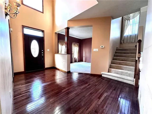 a view of an entryway with wooden floor and door