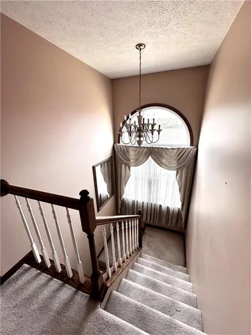 a view of staircase with railing and wooden floor