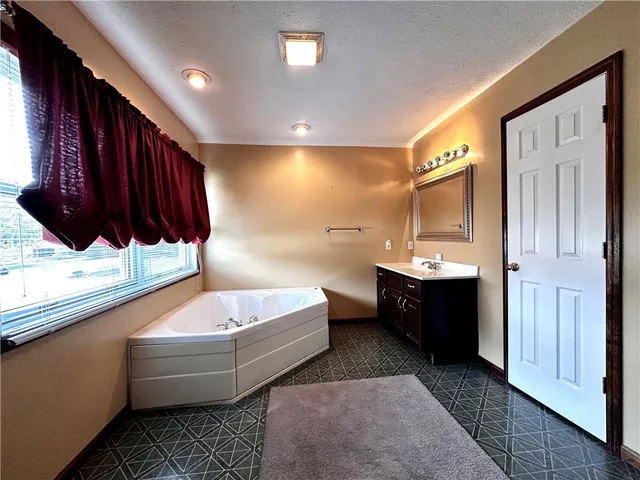 a bathroom with a tub sink and mirror