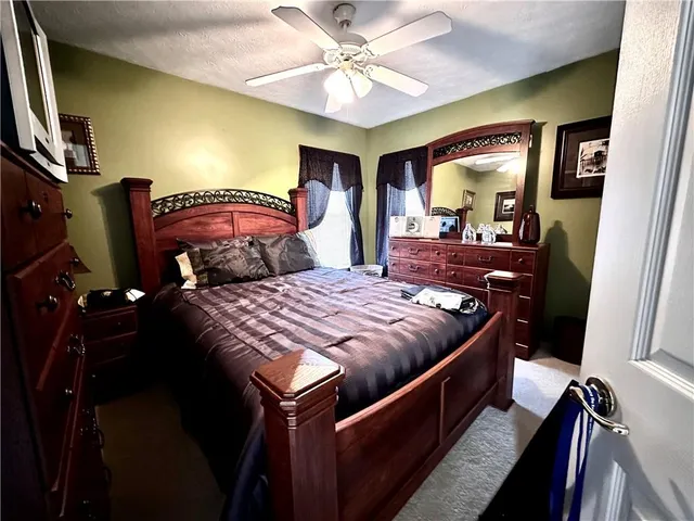 a bedroom with a bed and a chandelier with a flat tv screen