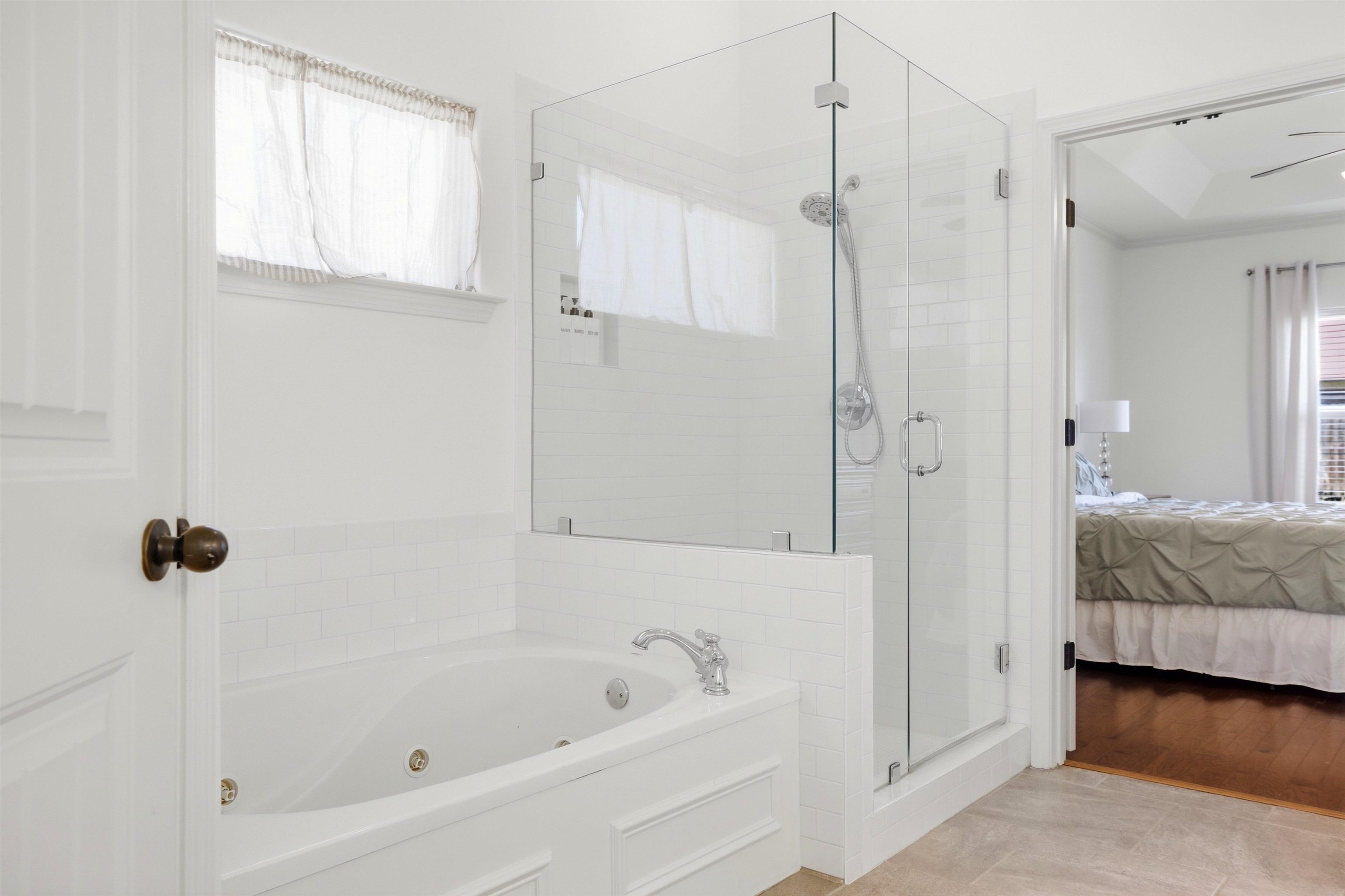 7920 Pips Ridge Lane Bartlett, TN 38133 - Photo 18 of 40 Soaking tub with jetted features, glass-enclosed shower, subway tile accents, and light-toned flooring