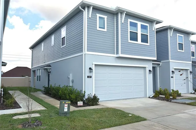 a front view of a house with a yard and garage