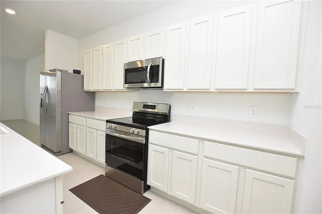 a kitchen with white cabinets and stainless steel appliances