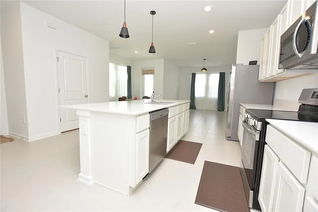a kitchen with stainless steel appliances kitchen island a sink stove and cabinets