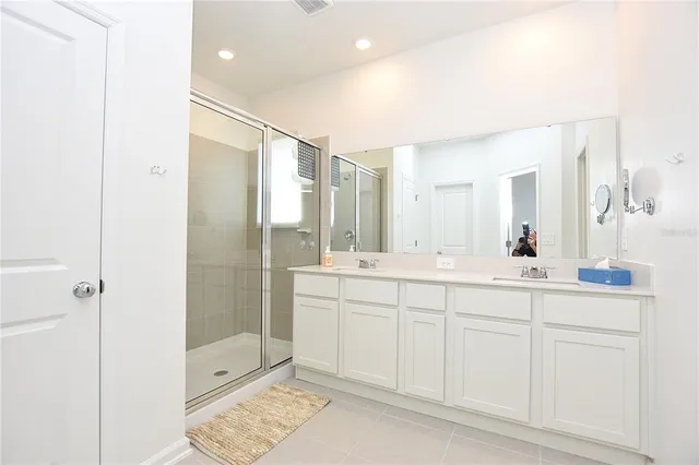 a spacious bathroom with a shower sink and mirror