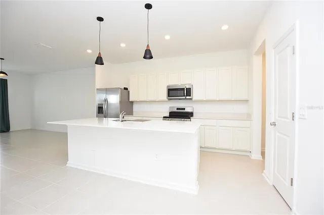a view of kitchen with stainless steel appliances wooden floor and window