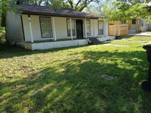 a view of a house with backyard and sitting area